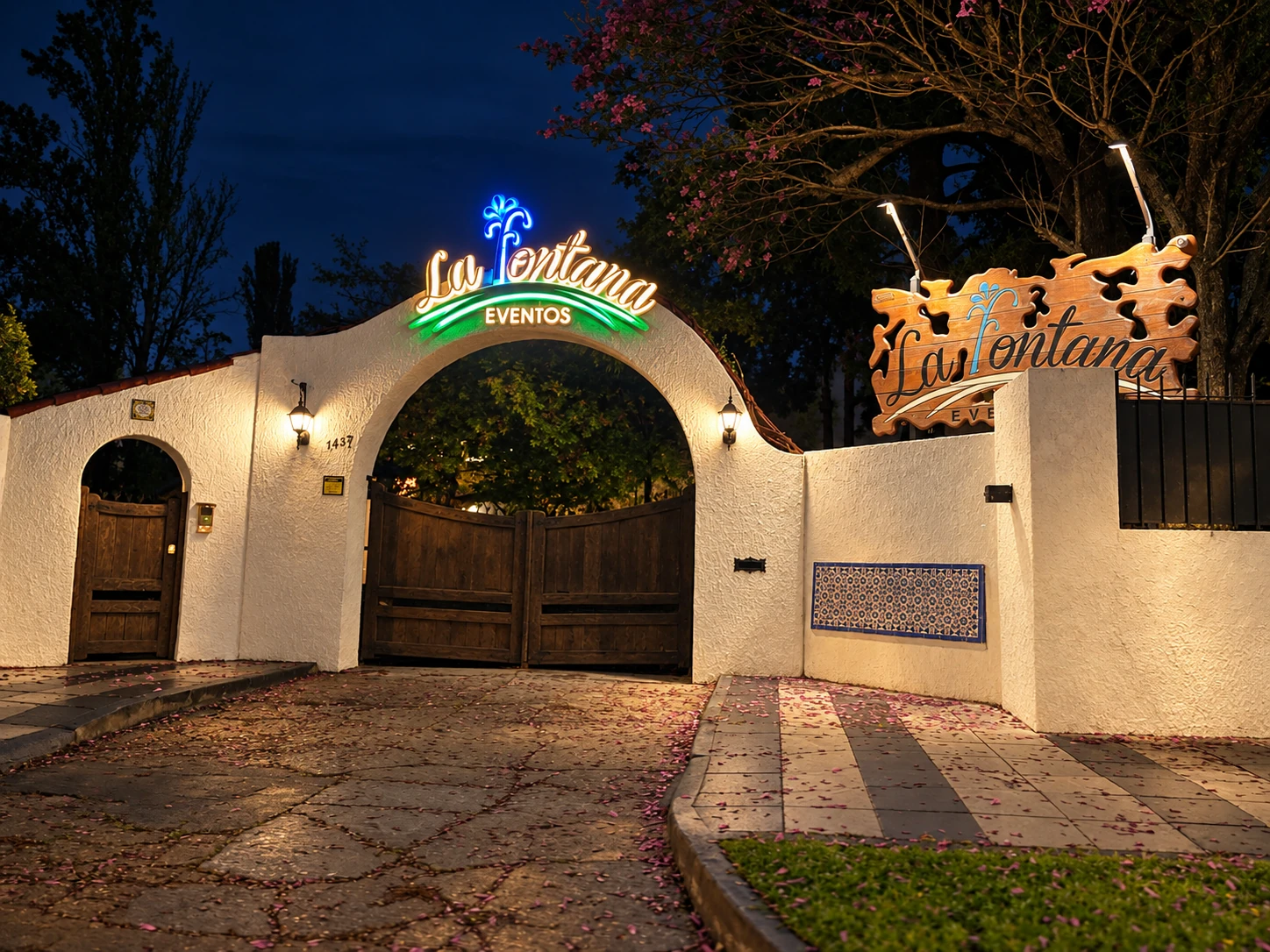 Entrada de La Fontana Eventos, con su arco y cartel iluminados de noche