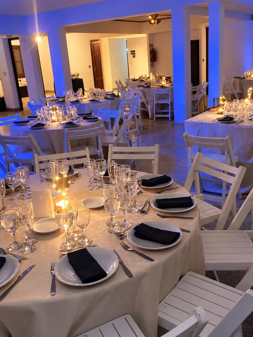 Salón con mesas redondas armadas e iluminación azul