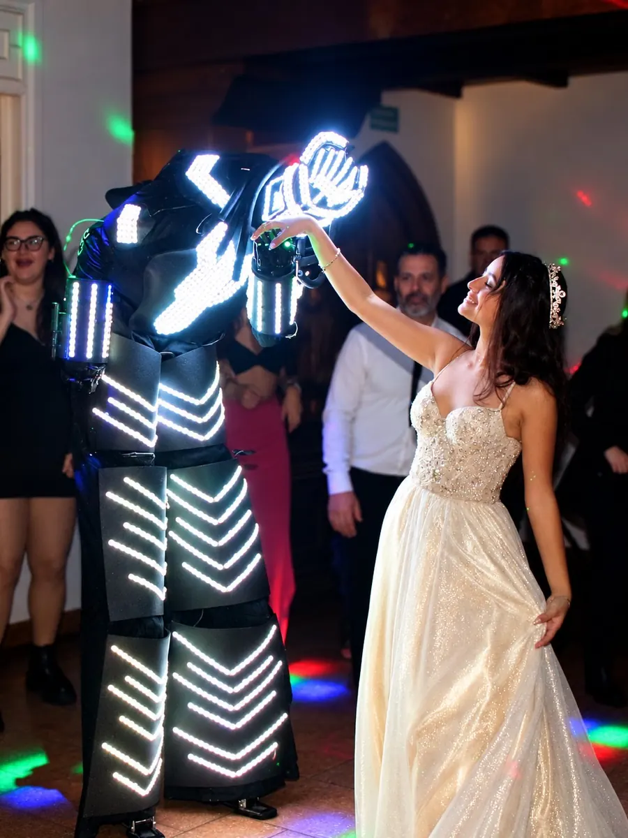 Quinceañera bailando con un robot de luces en la pista